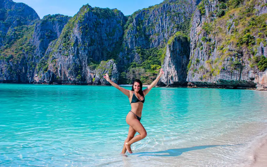 Shallow turquoise water in front of tall limestone cliffs