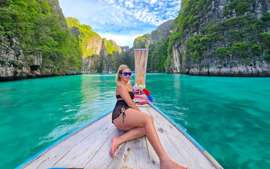 A private longtail boat drifting on the green water of a lagoon
